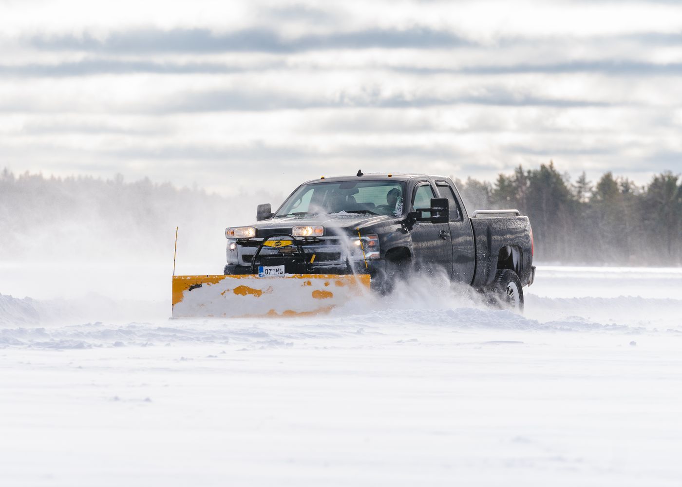 A pickup truck plowing through deep snow